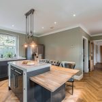 Bespoke modern home in Northwich with breakfast island, built-in appliances, and elegant pendant lights.