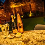 Champagne bottles and canapés on granite outdoor bar with soft evening lighting at 4 Bell Crescent, Davenham.