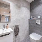 Ground-floor cloakroom at 4 Bell Crescent, Davenham, Cheshire with textured grey tiling, wall-hung WC and sleek modern basin.