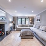 Contemporary living room featuring grey sectional sofa, statement lighting and garden access in a Davenham Cheshire home.