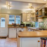 Family kitchen with feature oven, hob and farmhouse-style cabinetry in Hartford property