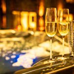 Close-up of champagne glasses beside bubbling Jacuzzi under ambient lighting at 4 Bell Crescent, Davenham.