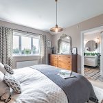 Principal suite view towards en-suite bathroom, showing warm textures and elegant proportions