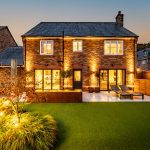 Rear landscaped garden of 4 Bell Crescent, Davenham, Cheshire, property for sale in Davenham, captured at twilight with feature planting and outdoor lighting.
