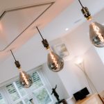 Designer pendant lighting above the kitchen island — a contemporary feature within a high-end barn conversion in Cuddington, Cheshire