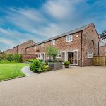 Side elevation showing resin driveway and landscaped gardens at a luxury barn conversion in Cuddington, Cheshire.