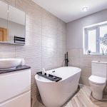 Luxury bathroom with freestanding bath and ripple tiles in a Kingsmead Cheshire property.