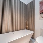 Family bathroom at Blossoms, Bostock featuring freestanding bath, slatted wall detail and modern design.
