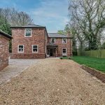 Luxury home in Northwich, Cheshire, featuring a red-brick façade, gravel driveway, and detached garage — presented by J Lord & Co