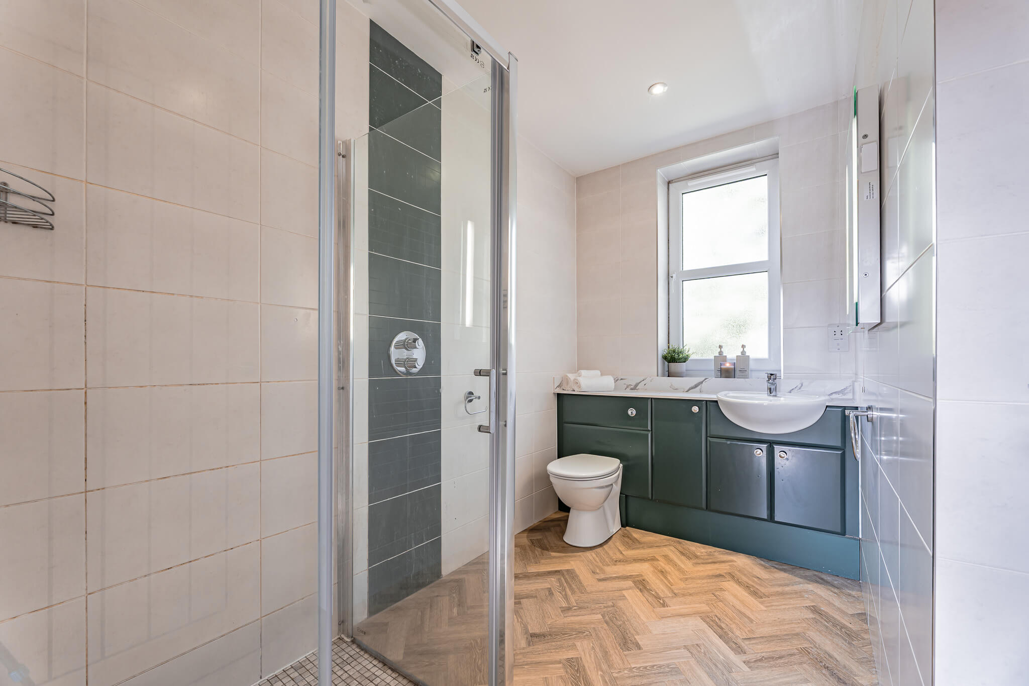 Luxury home in Northwich featuring a stylish en-suite bathroom with walk-in shower and herringbone flooring.