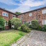 Traditional brick courtyard and green door entrance at Blossoms, Bostock — luxury Cheshire home.