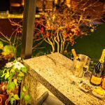 Elevated view of outdoor bar area overlooking landscaped garden with subtle lighting at 4 Bell Crescent, Davenham, Cheshire.