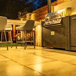 Bar seating and tiled terrace illuminated by garden lighting at 4 Bell Crescent, Davenham.