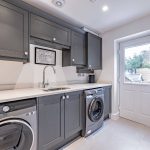 Modern utility room with dark shaker cabinets, integrated appliances and side door in a Davenham Cheshire property for sale