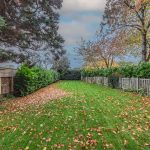 Generously sized rear garden at a detached home on Church Street, Davenham featuring a long lawn bordered by mature hedging and established trees