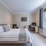 Large double bedroom with neutral décor in executive Hartford residence.