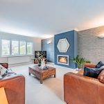 Bright living room with leather sofas and feature fireplace at Brock Lodge, Northwich Cheshire
