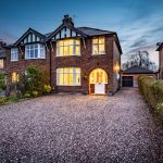 Twilight view of the front elevation with illuminated bay windows and gravel driveway at 46 Hodge Lane Hartford