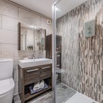 Modern shower room with tiled feature wall at Orchard House Lach Dennis Cheshire