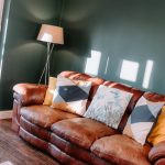 Snug lounge with leather sofa and feature wall at Orchard House Lach Dennis Cheshire