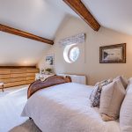 Characterful cottage bedroom with exposed beams and built-in storage at Hall Green Barn in Acton Bridge