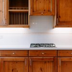 Kitchen detail showing worktop, gas hob and wooden cabinetry in The Barns, Bostock