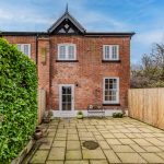 Rear elevation with patio area, outdoor seating space and garden access in The Barns, Bostock