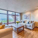 Sitting room with wood flooring and open countryside outlook through full-height glazing at Cliff Road