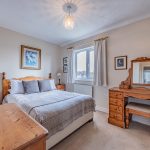 Double bedroom with wooden furniture and natural light in Davenham property