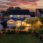 Twilight aerial view of 215 Hartford Road, Davenham showing landscaped gardens and illuminated rear entertaining spaces.