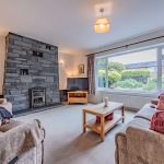 Spacious dual-aspect lounge within this four-bedroom detached home in Davenham, centred around a striking slate fireplace and enjoying natural light from two elevations