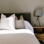 Bedroom detail at The Barns, Bostock Hall Estate, featuring soft neutral styling, upholstered headboard and contemporary furnishings