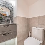 Contemporary en suite at The Barns, Bostock Hall Estate, with textured feature wall, vanity storage and modern fittings