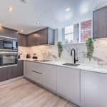 Contemporary fitted kitchen at The Barns, Bostock Hall Estate, featuring marble-effect surfaces, integrated appliances and modern cabinetry