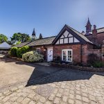 Front elevation of The Barns at Bostock Hall Estate, showcasing character brickwork, cobbled approach and courtyard setting