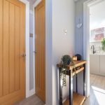 Internal hallway at The Barns, Bostock Hall Estate, connecting the living space to the contemporary kitchen with natural light throughout