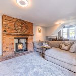 Character lounge at The Barns, Bostock Hall Estate, featuring exposed brick fireplace, log burner and soft contemporary interiors