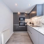 Modern galley kitchen at The Barns, Bostock Hall Estate, with integrated appliances, recessed lighting and contemporary finishes