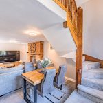 Open-plan living and dining space at The Barns, Bostock Hall Estate, featuring exposed brickwork, staircase and character detailing