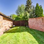 Rear garden at The Barns, Bostock Hall Estate, featuring lawned garden, brick boundary walls and character architecture