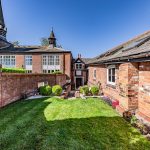 Private landscaped garden at The Barns, Bostock Hall Estate, with mature planting, lawn and enclosed outdoor space