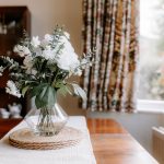 Dining area with bay window and floral table styling in Davenham home