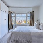 Main double bedroom with large bay window and fitted furnishings