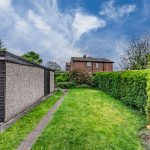 Lawn garden with mature hedging and detached garage