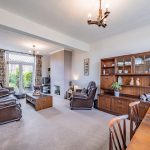 Living room with feature fireplace and doors opening to the rear garden