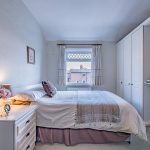 Second bedroom with fitted storage and soft neutral interiors