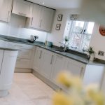 Modern shaker kitchen with stone worktops and window outlook at Pear Tree Farm in Davenham.