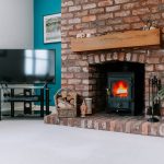 Exposed brick fireplace with wood-burning stove at Pear Tree Farm in Davenham.