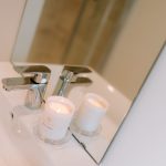 Bathroom sink detail with chrome tap and candle styling