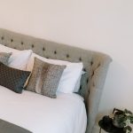 Bedroom detail with upholstered headboard and layered cushions
